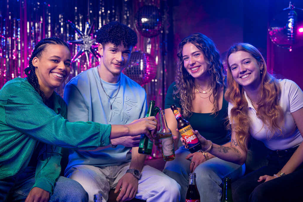 Freunde lachen und trinken Bier beim Karaoke-Abend