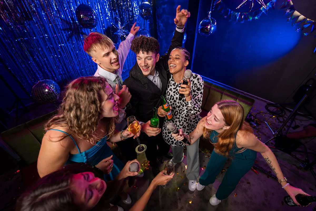 Gruppe feiert Geburtstagsparty mit Karaoke und Cocktails